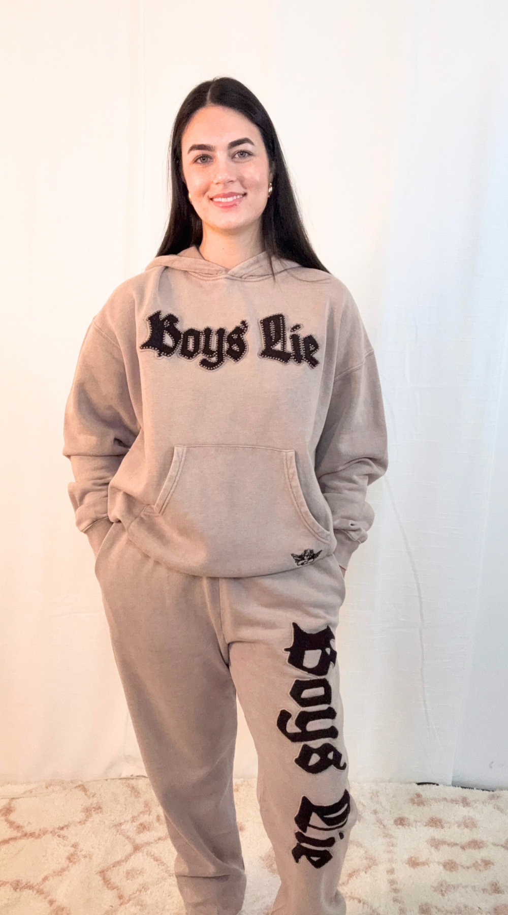Model wearing Boys Lie Rocker Kimmy hoodie in taupe with bold Boys Lie graphic lettering