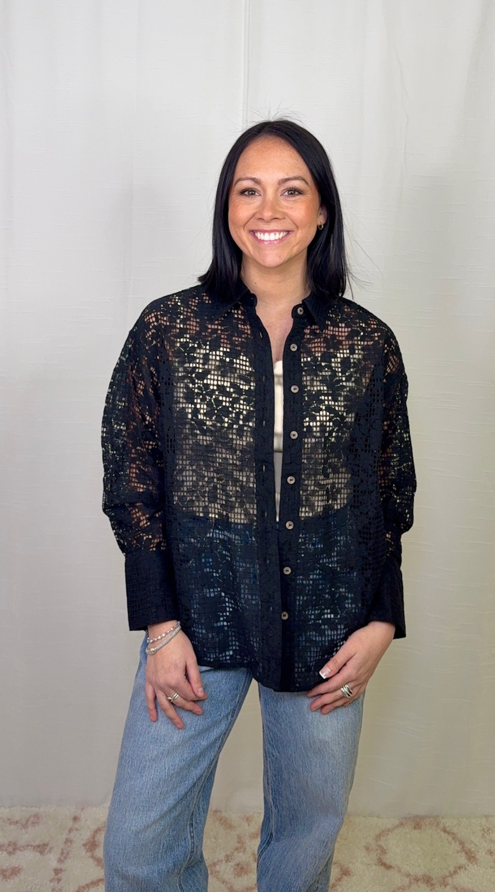 Black lace long sleeve button down top worn with blue jeans