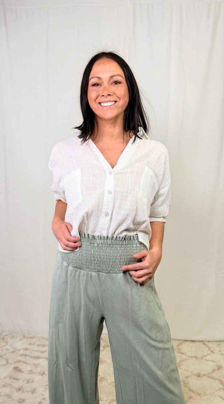 Woman wearing sage green smocked waist wide leg cotton pants