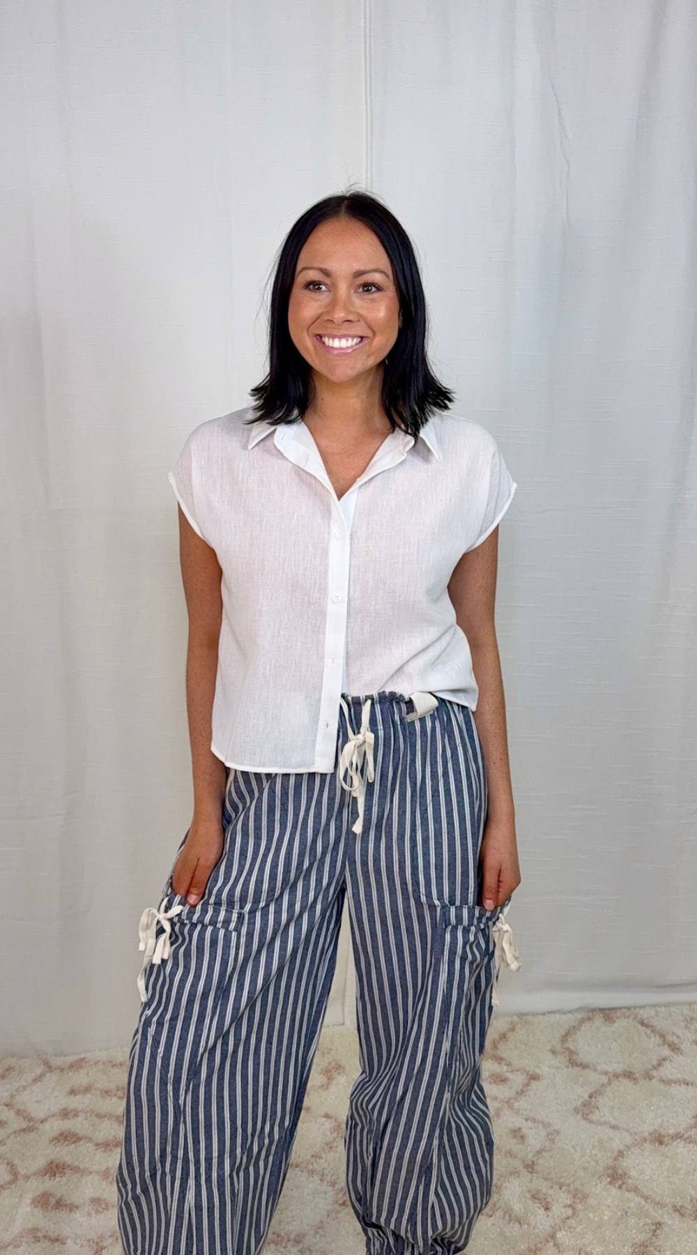 Blue and white striped linen blend drawstring pants worn with a white top