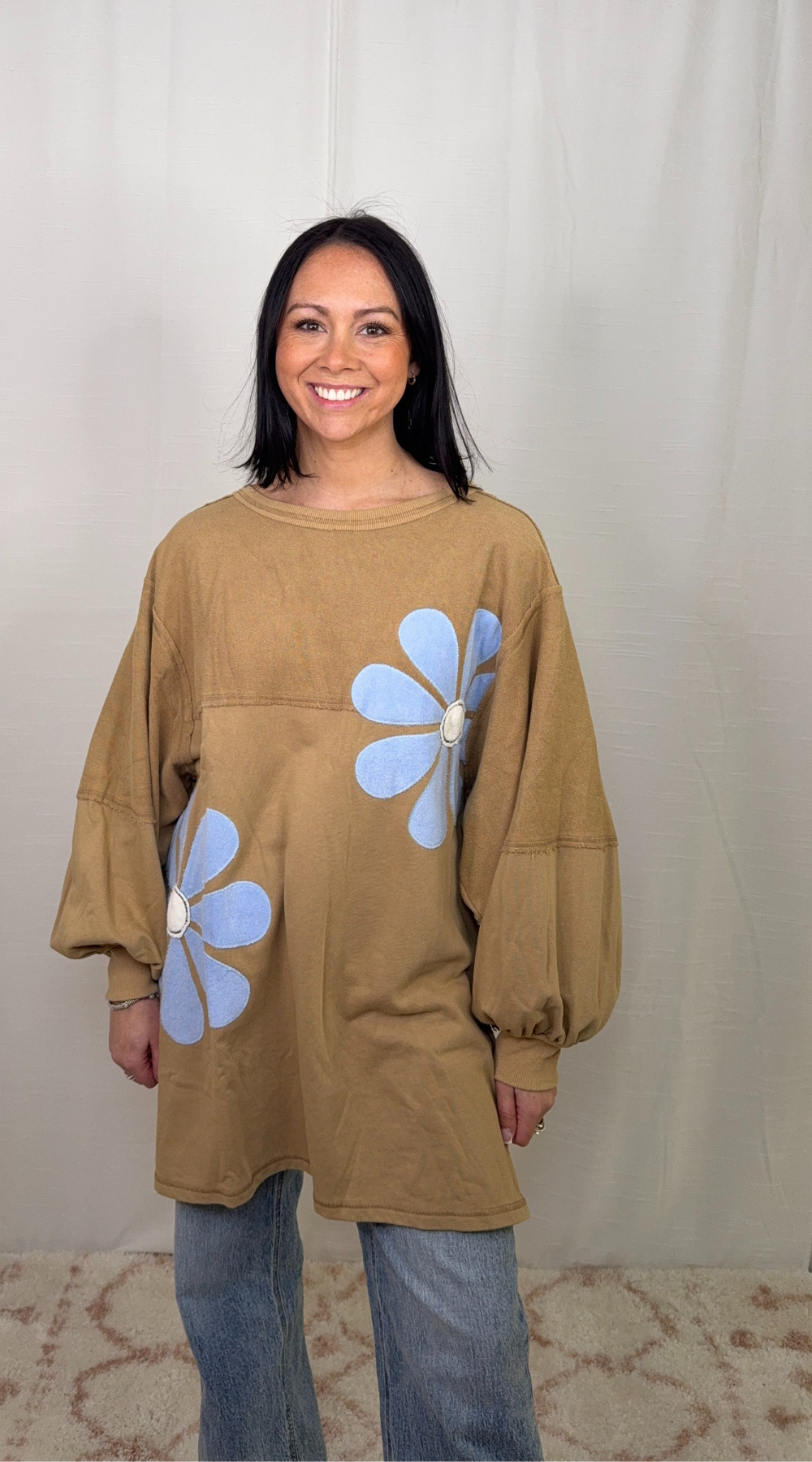 Brown oversized sweatshirt dress with floral appliqué worn as a casual outfit